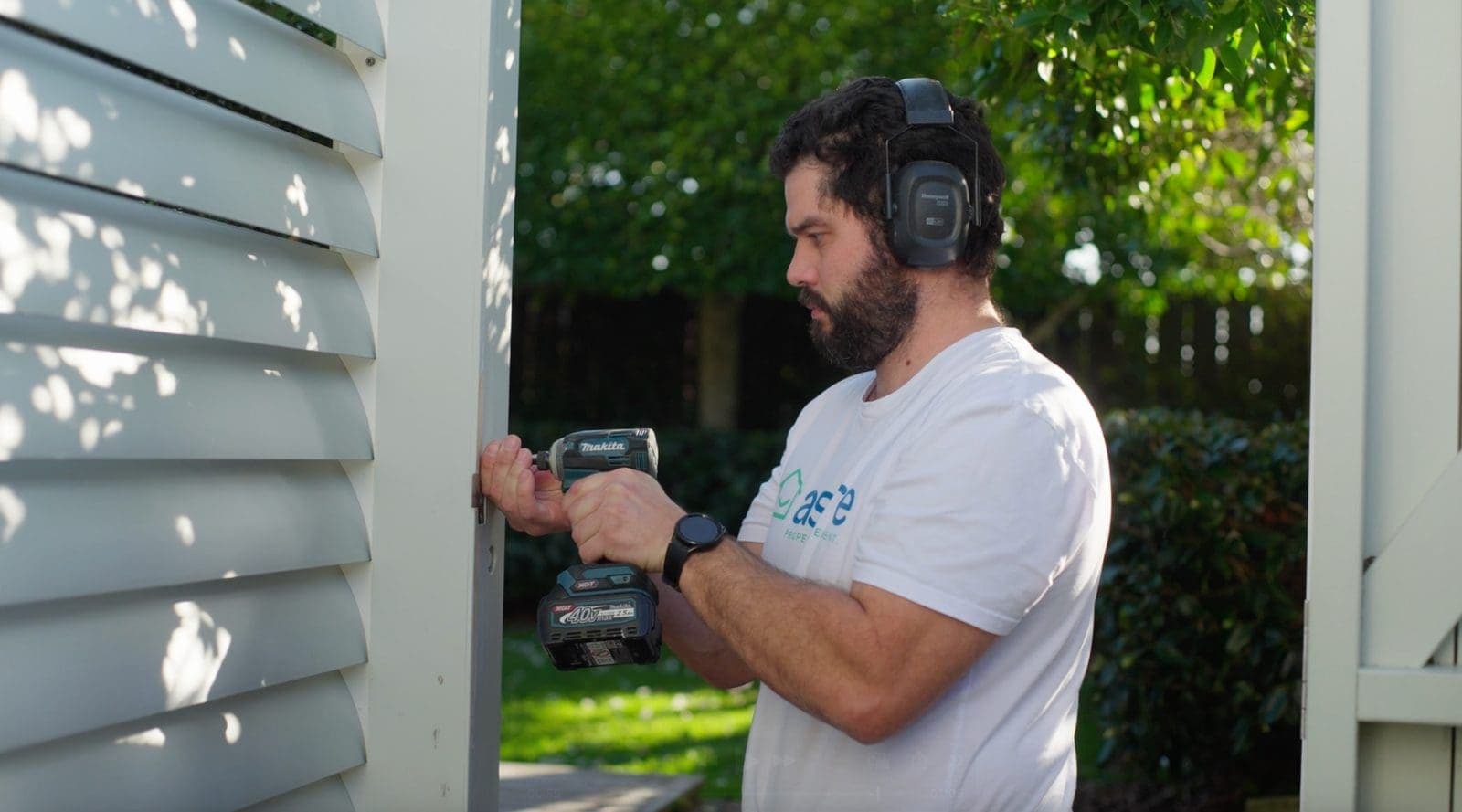 An Aspire maintenance technician using a cordless drill to repair a louvred exterior panel