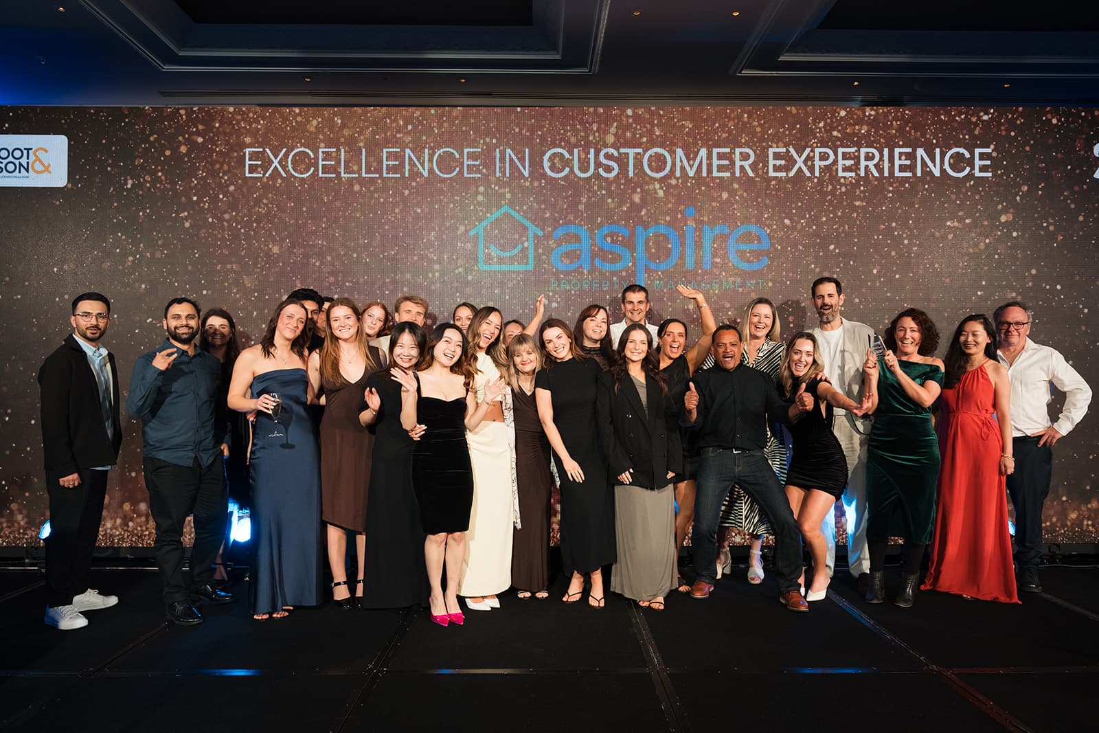 The Aspire Property Management team on stage with the Excellence in Customer Experience trophy at the 2026 Auckland Business Awards