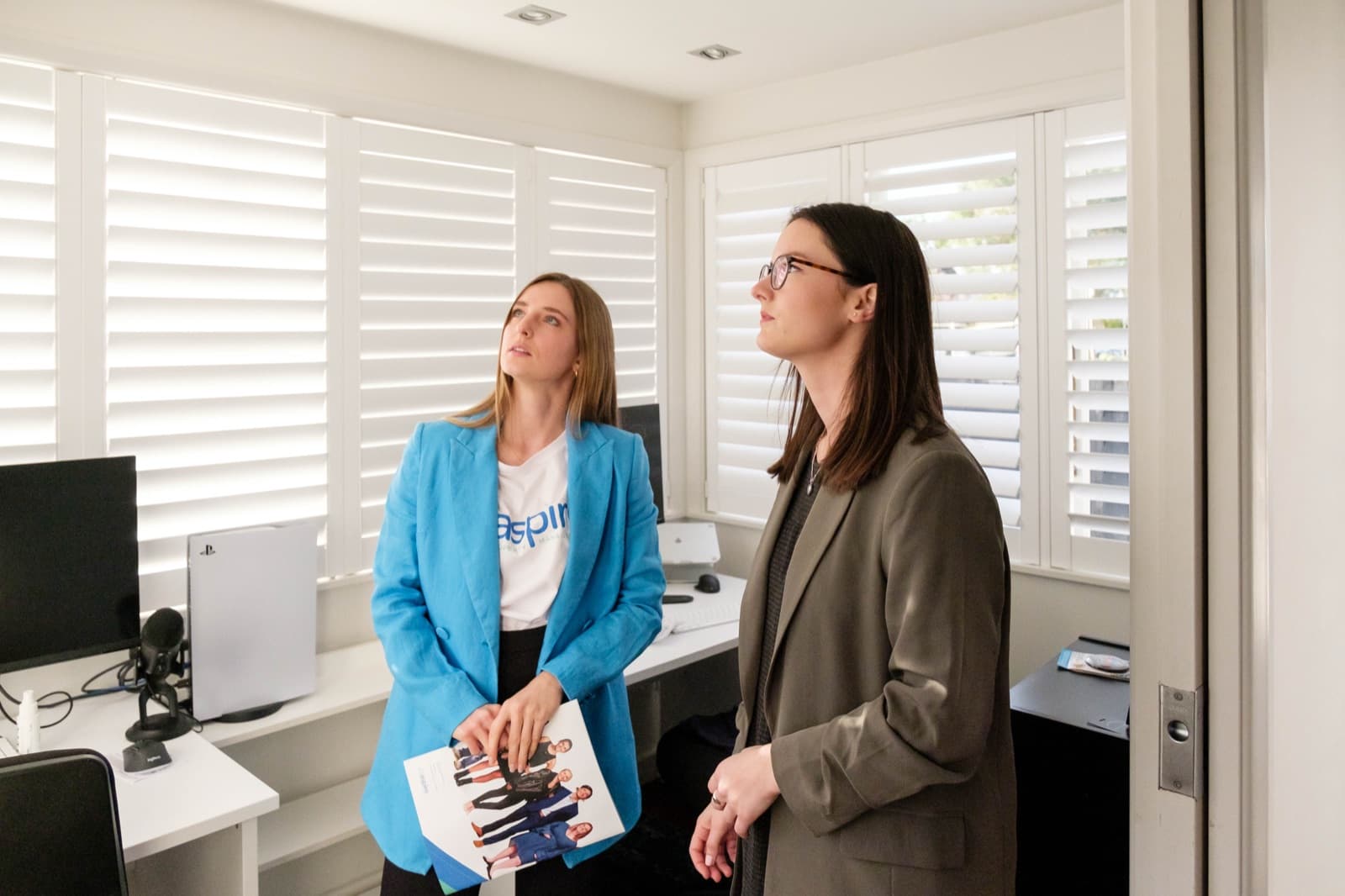 Two Aspire team members look up at the ceiling while checking a room during a rental property inspection