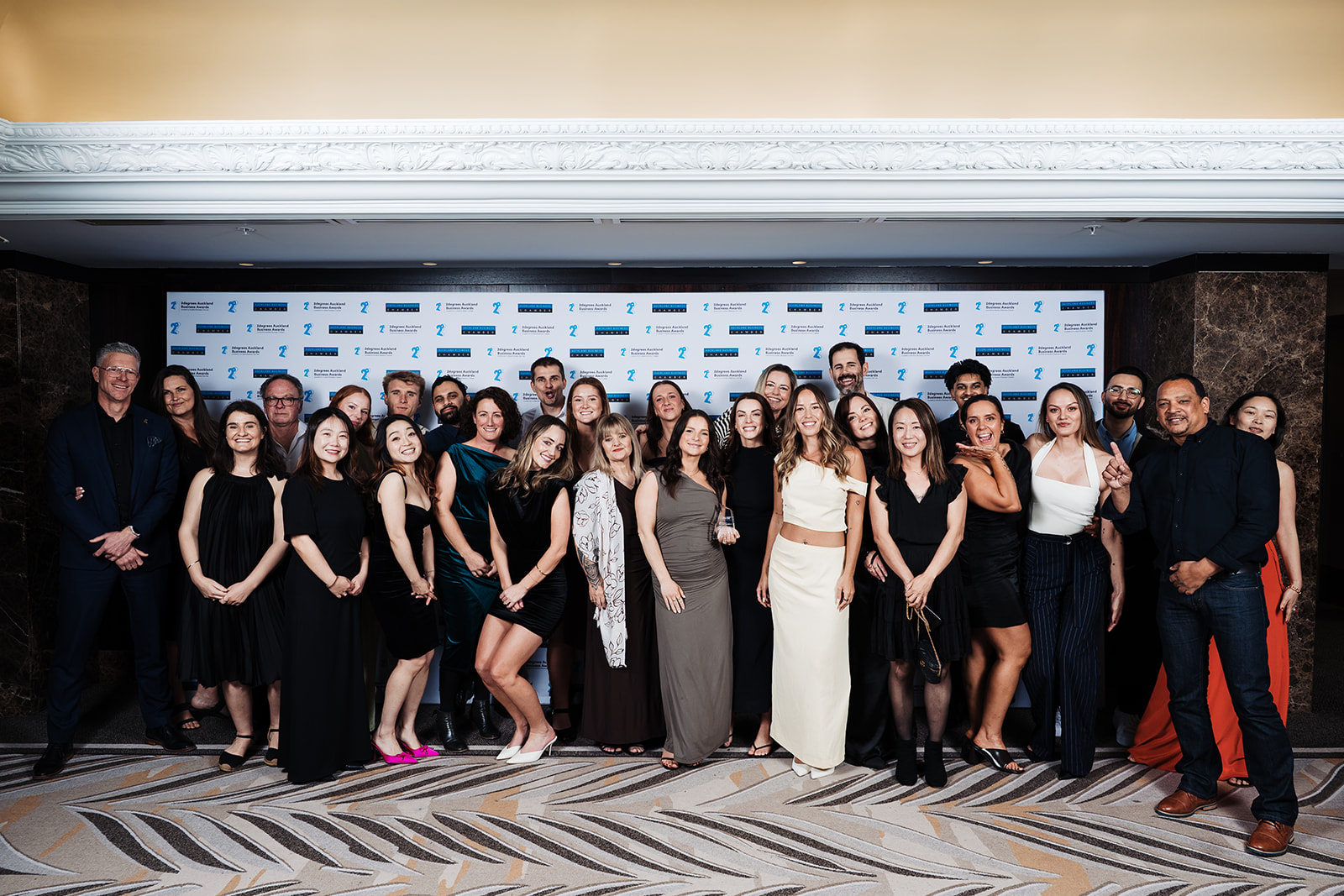 Henry Barfoot of Barfoot & Thompson on the far left with most of the Aspire Property Management team, photographed in front of the awards backdrop at the Cordis Hotel