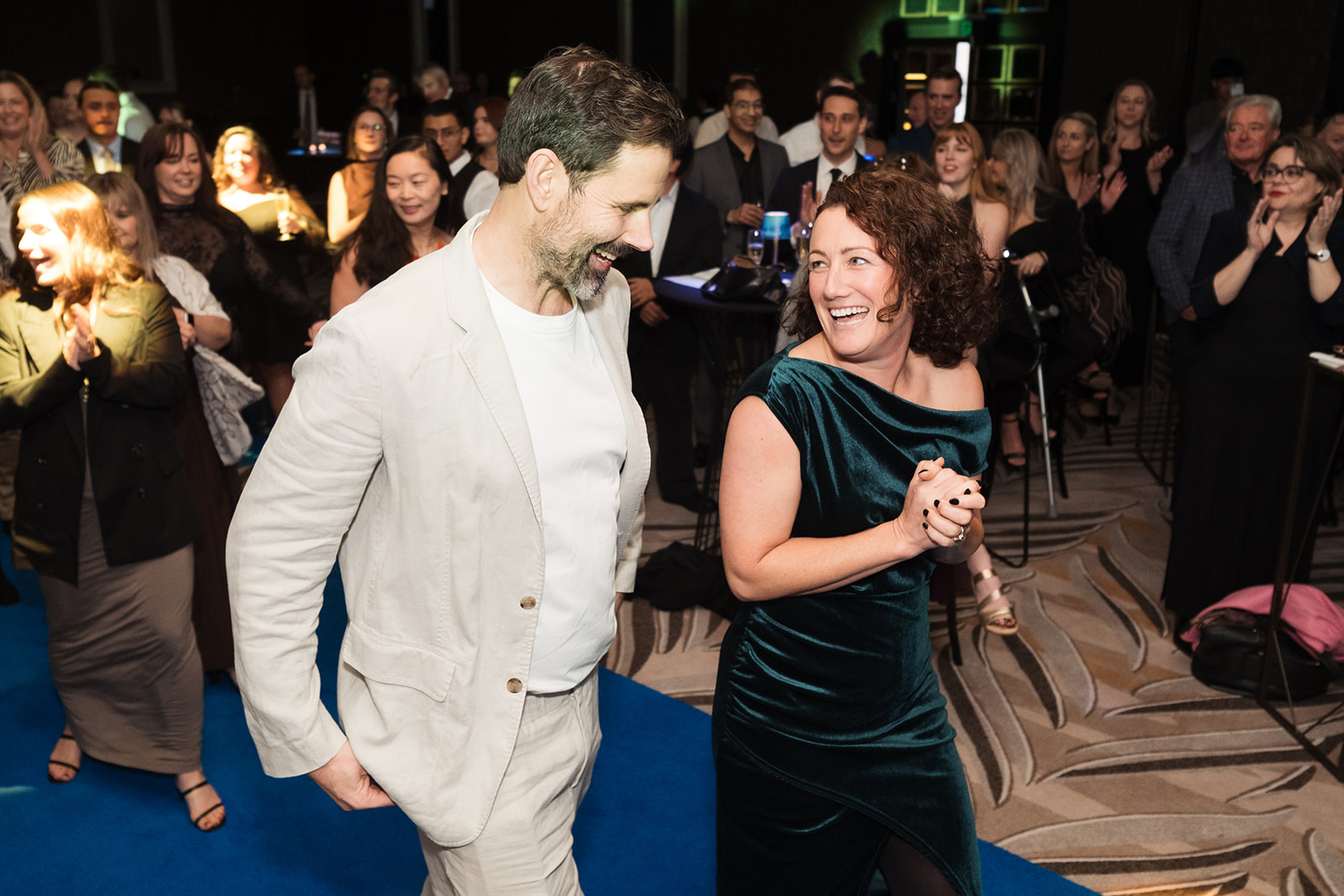Mike Atkinson and Daisy Sievewright of Aspire Property Management walk up to the stage through applauding guests at the 2026 Auckland Business Awards